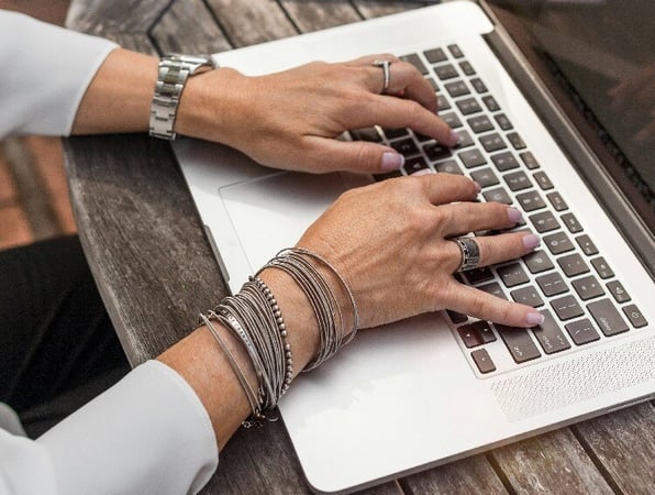 hands typing at laptop